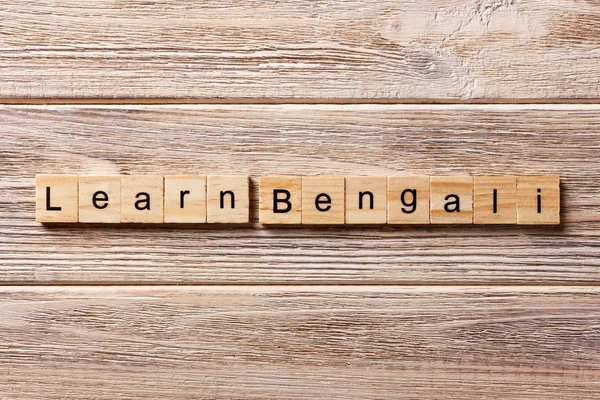 learn Bengali word written on wood block. learn Bengali text on table, concept