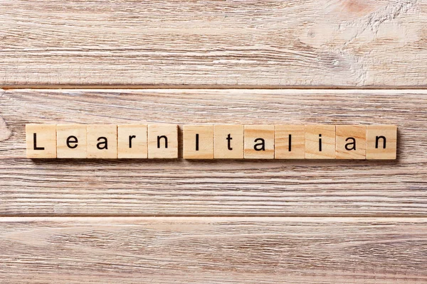 learn italian word written on wood block. learn italian text on table, concept