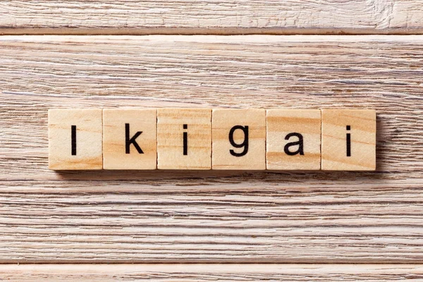 Tahta bloğa yazılmış ikigai kelimesi. Masada ikigai metni, konsept