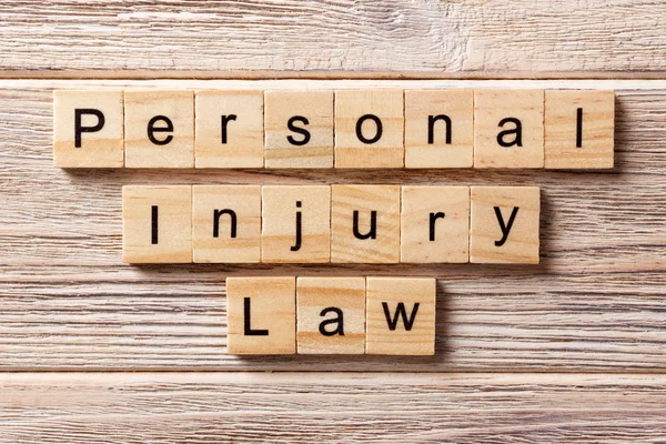 Kata hukum luka pribadi ditulis di balok kayu. teks personal injury law di atas meja, konsep — Stok Foto