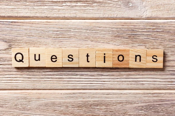 Questions word written on wood block. Questions text on table, concept