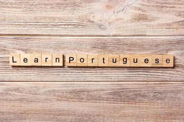 learn portuguese word written on wood block. learn portuguese text on table, concept