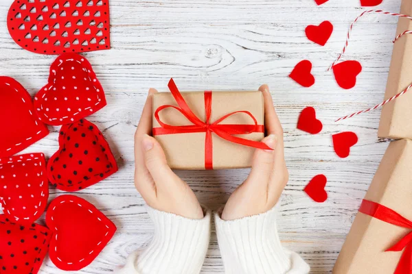 Valentines Day background. girl hand give valentine gift box with a red heart inside on a white old wooden table. Valentine day — Stock Photo, Image