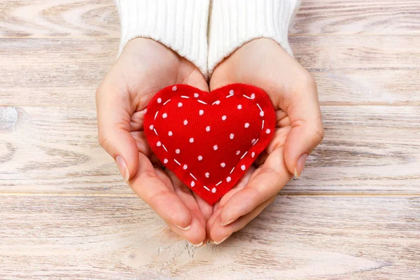 Una mujer tiene un corazón rojo en sus manos. Concepto de amor — Foto de Stock