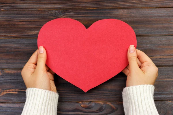 Mano de mujer sosteniendo papel rojo en forma de corazón. espacio de copia — Foto de Stock