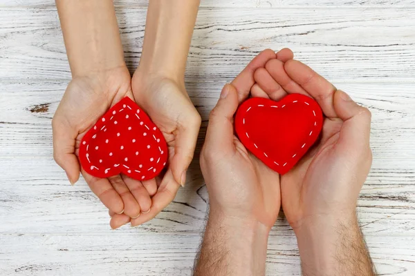 Pareja enamorada sosteniendo un corazón rojo en sus manos. Concepto de San Valentín — Foto de Stock