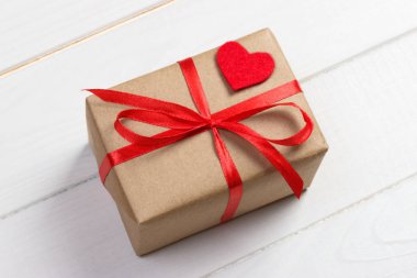 Sevgiliye arka plan. Kırmızı kalp, şerit ve hediye kutusu ahşap arka plan üzerinde