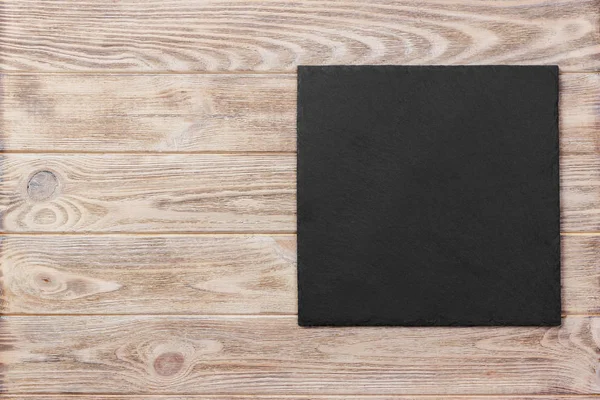 Łupek tablica na drewnianym stole na podłoże drewniane — Zdjęcie stockowe