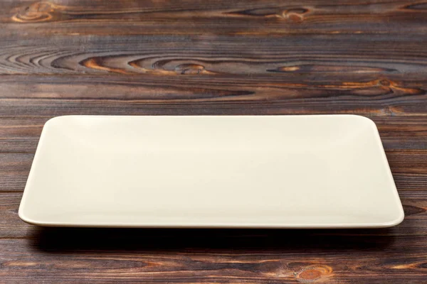 Piastra rettangolare bianca su sfondo in legno. vista dall'alto — Foto Stock