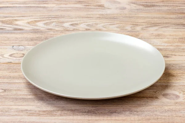 Пустая круглая тарелка для еды на деревянной площадке. Перспективный взгляд — стоковое фото