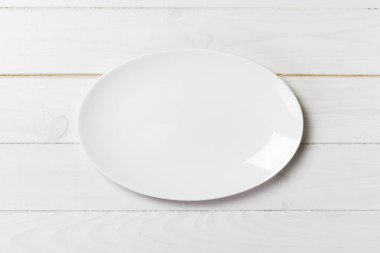 Ahşap bir arka planda boş beyaz yemek tabaklarının üst görünümü