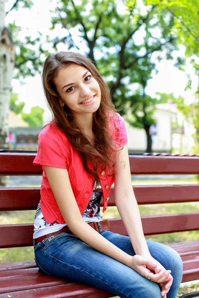 Girl sitting on a bench — Stock Photo, Image