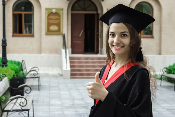 Retrato de mujer en su día de graduación. Pulgares arriba. Universidad. Concepto de educación, graduación y personas . —  Fotos de Stock