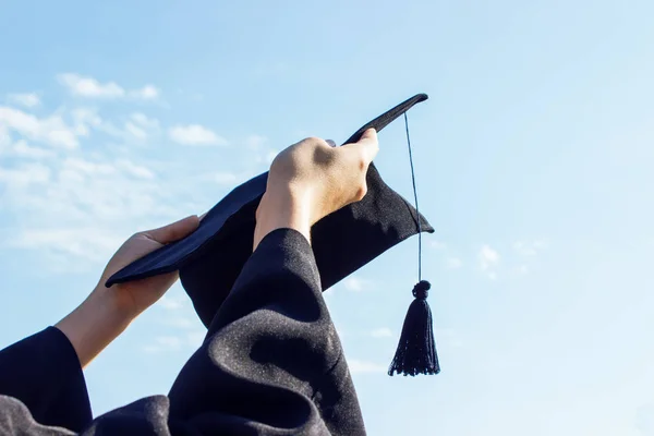 Graduate celebrating with cap in her hand,feeling so proud and happiness in Commencement day — Stock Photo, Image