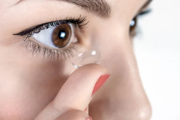 Ung kvinna sätta kontaktlins i hennes högra öga, närbild — Stockfoto
