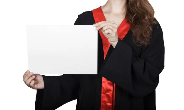 Estudante de pós-graduação espreitando por trás de um painel em branco. Retrato de menina feliz em vestido de graduação com placa de cartaz, isolado no fundo branco. Jovem segurando banner vazio — Fotografia de Stock