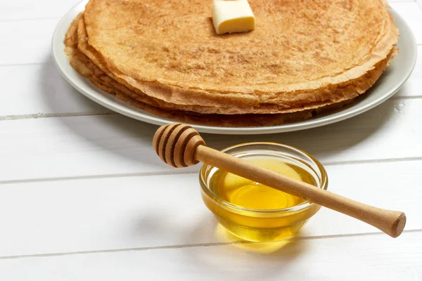 Pila de sabrosos panqueques con mantequilla y miel para el desayuno — Foto de Stock