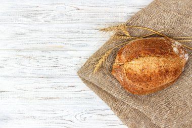 Lezzetli ekmek arka plan. bütün tahıl ekmeği kuru buğday, üstten görünüm Beyaz ahşap zemin üzerine