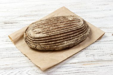 Çavdar ekmek kese kağıdı ile ahşap arka plan üzerinde loafs. Üstten Görünüm