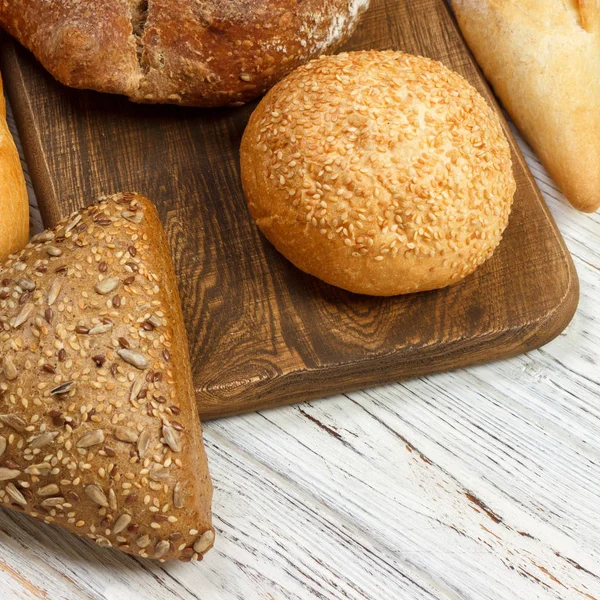 Assortment of baked bread on wooden table background. top view with copy space — Stock Photo, Image