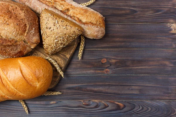 Pan casero de pan de trigo horneado sobre fondo de madera. vista superior con espacio de copia — Foto de Stock