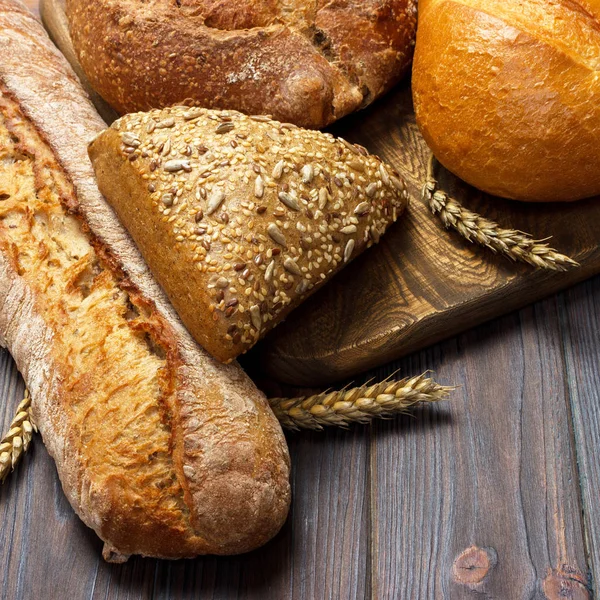 Pan fresco y trigo en la madera. vista superior — Foto de Stock