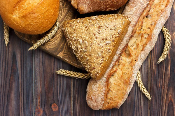 Pan y trigo sobre fondo de madera blanca. vista superior con espacio de copia — Foto de Stock