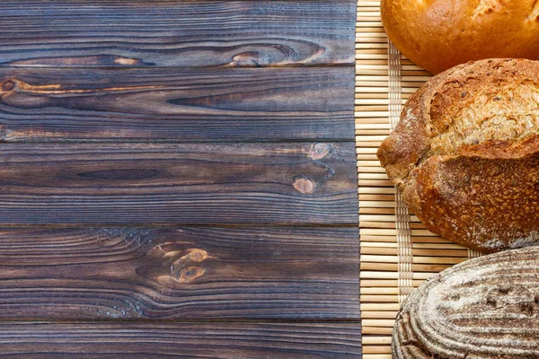 Surtido de pan horneado en mesa de madera — Foto de Stock