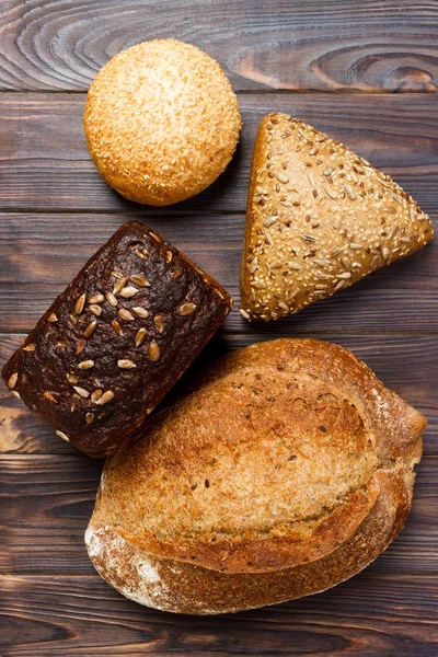 Fondo panadería, surtido de pan sobre fondo de madera negra. Vista superior con espacio de copia — Foto de Stock