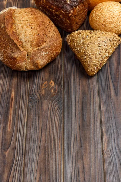 Fondo panadería, surtido de pan sobre fondo de madera negra. Vista superior con espacio de copia — Foto de Stock