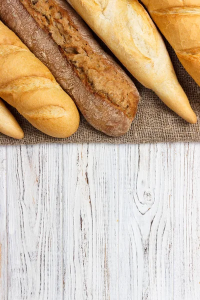 Loaf of bread on a white rustic table. baguette loaf