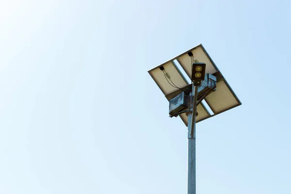 Street lamp with solar cell panel on blue sky background