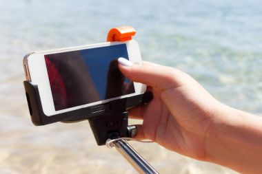 Kız kamera selfie Stick denizin içinde ayarlar