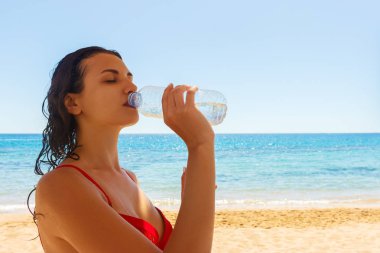 Kırmızı mayo içme suyu bir tatil gününde güzel esmer kız