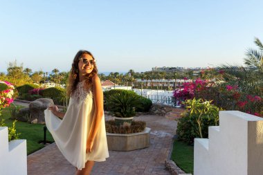 Kız güneşe bakıyor. güneş gözlüklü kız sevinir