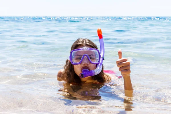 Женщина на пляже каникулы с трубкой лежа в море с маской подводного плавания улыбаясь счастливо наслаждаясь солнцем в солнечный летний день. молодая женщина с подводным снаряжением на берегу моря — стоковое фото