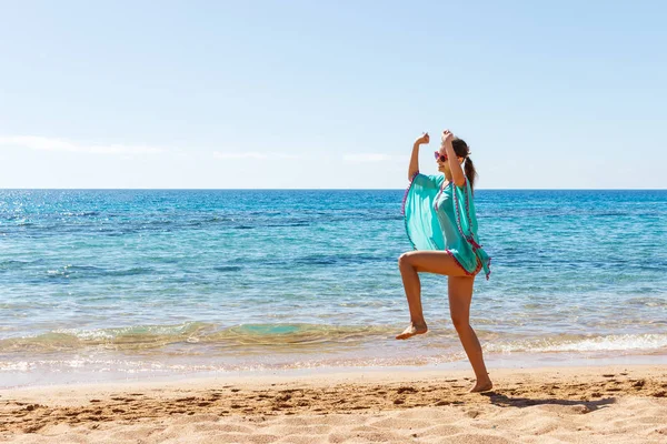 Beach vacation success woman jumping of joy and happiness. girl jump on a beach on summer vacations travel