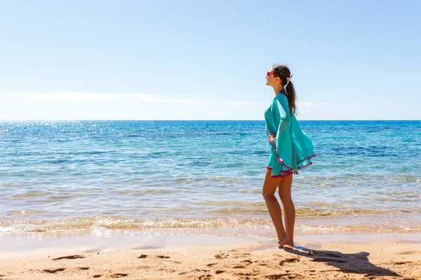 Žena v bílém oblečení osvěžující na pláži za slunečného dne — Stock fotografie