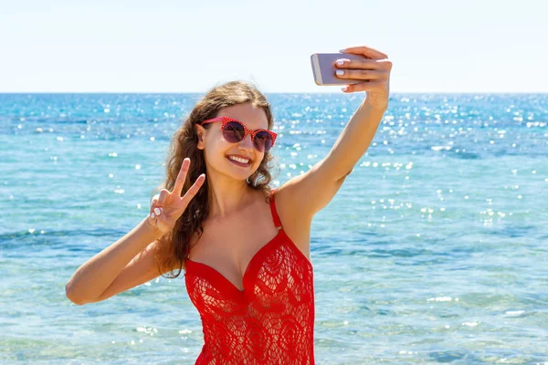 Joven mujer sexy vestida con traje de baño de moda utilizando la cámara del teléfono móvil para tomar selfie —  Fotos de Stock