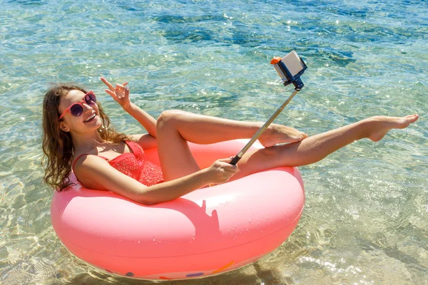 Nadar louco com donut inflável faz selfie na praia no dia ensolarado do verão — Fotografia de Stock