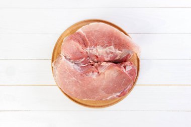 taze domuz yuvarlak ahşap kesme tahtası üzerinde büyük parçası. Ahşap arka plan üzerinde Üstten Görünüm