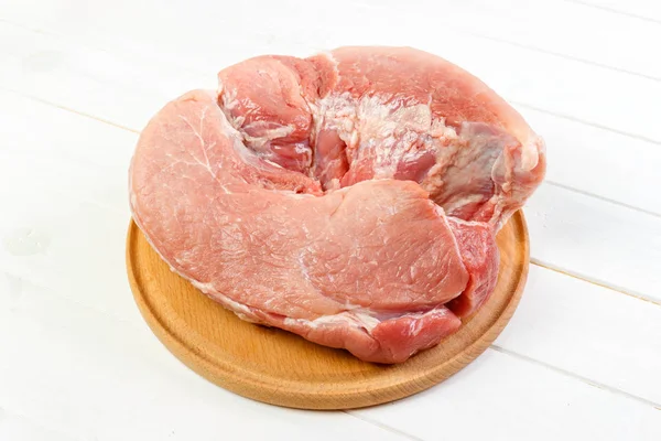 Friss sertéshús készen áll a szakács a vágódeszka. sertéshús, fehér fa háttér — Stock Fotó