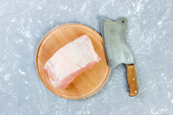 Nyers vágott shoulder pork a fedélzeten a késsel vagy konyhai ax. fejsze, friss nyers hús szürke beton alapon — Stock Fotó