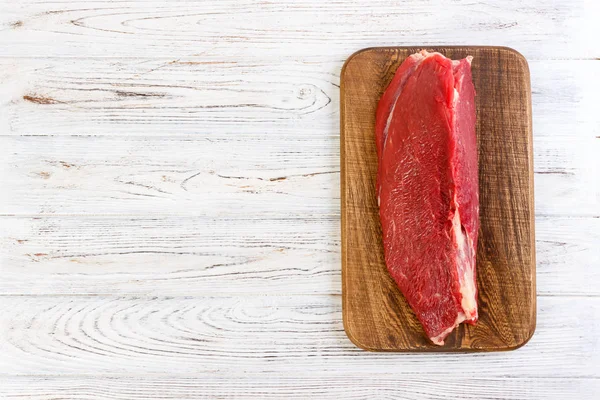 Κόκκινο φρέσκο νωπό βόειο κρέας μοσχαρίσιο φιλέτο σε ξύλο κοπής. λευκό φόντο ξύλινη με αντίγραφο χώρου — Φωτογραφία Αρχείου