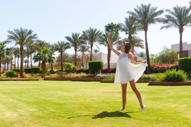 Eğleniyor ve rahatlatıcı yaz tatil tropikal parkta zevk kadın