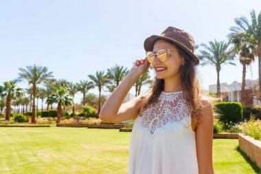Eğleniyor ve rahatlatıcı yaz tatil tropikal parkta zevk kadın
