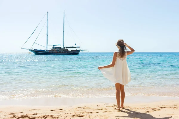 Boldog nő nyári fehér ruha, a strandon. lány, pihenés, és élvezi a béke a nyaralás — Stock Fotó