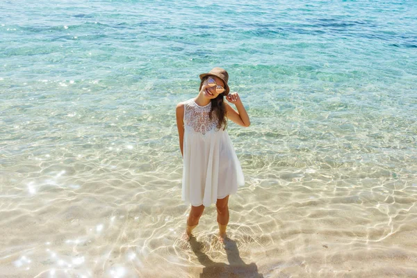 Woman joyful and happy in white dress at the beach