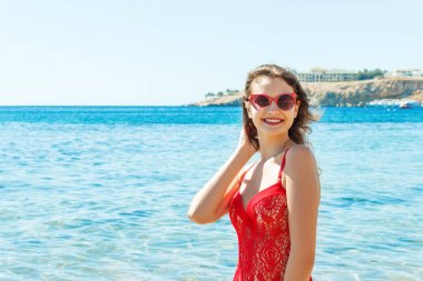 Kırmızı bir mayo içinde sahilde poz güzel mutlu esmer kız