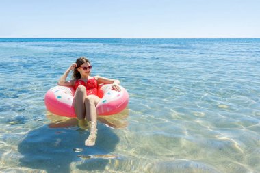 Şişme çörek ile sahilde yaz güneşli bir günde Yüzme kadın